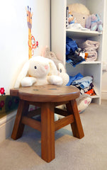Footstool with plush toys and shelving unit visible in the background