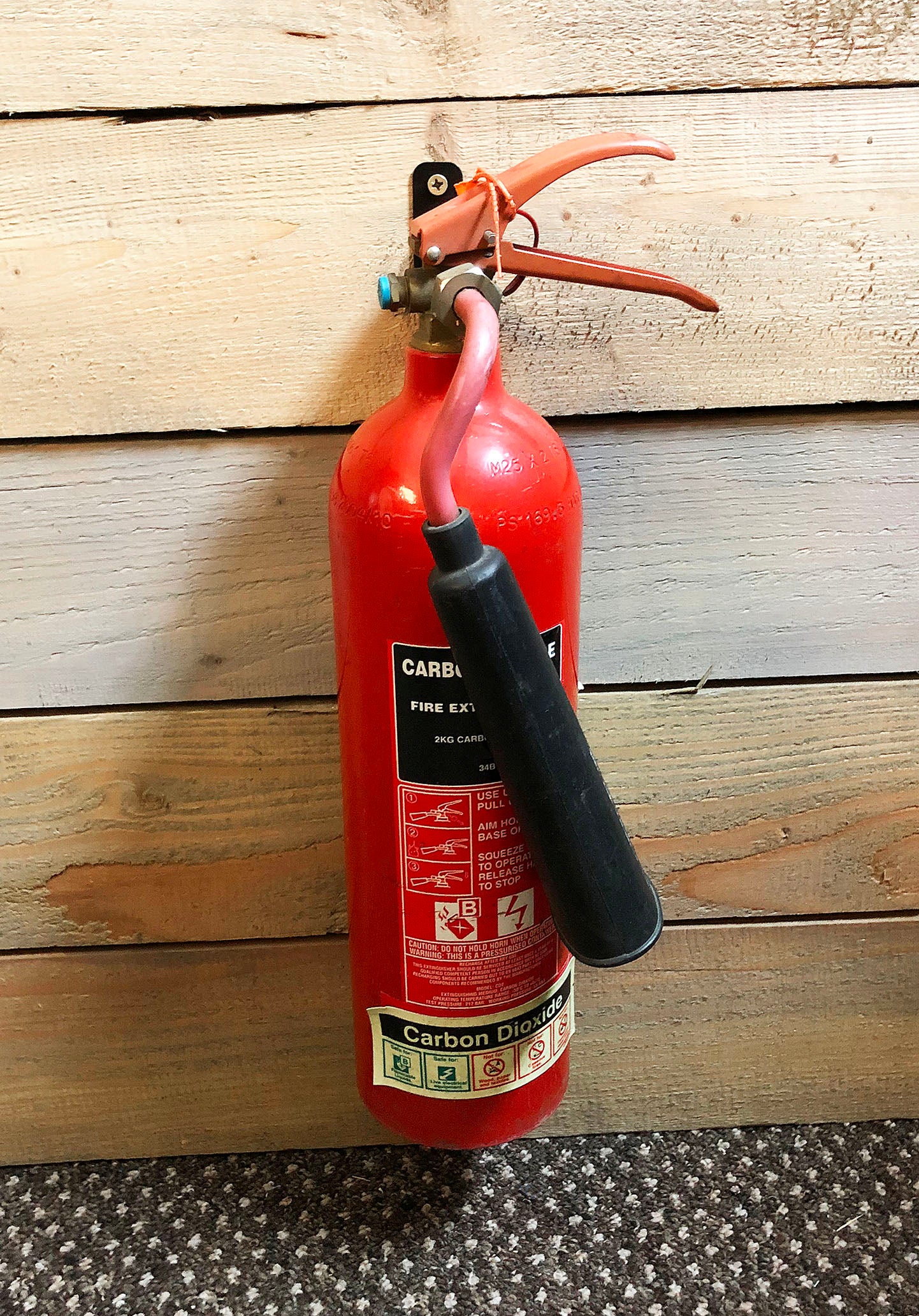 Front View of Wall Mount Fire Extinguisher Bracket installed in an office setting