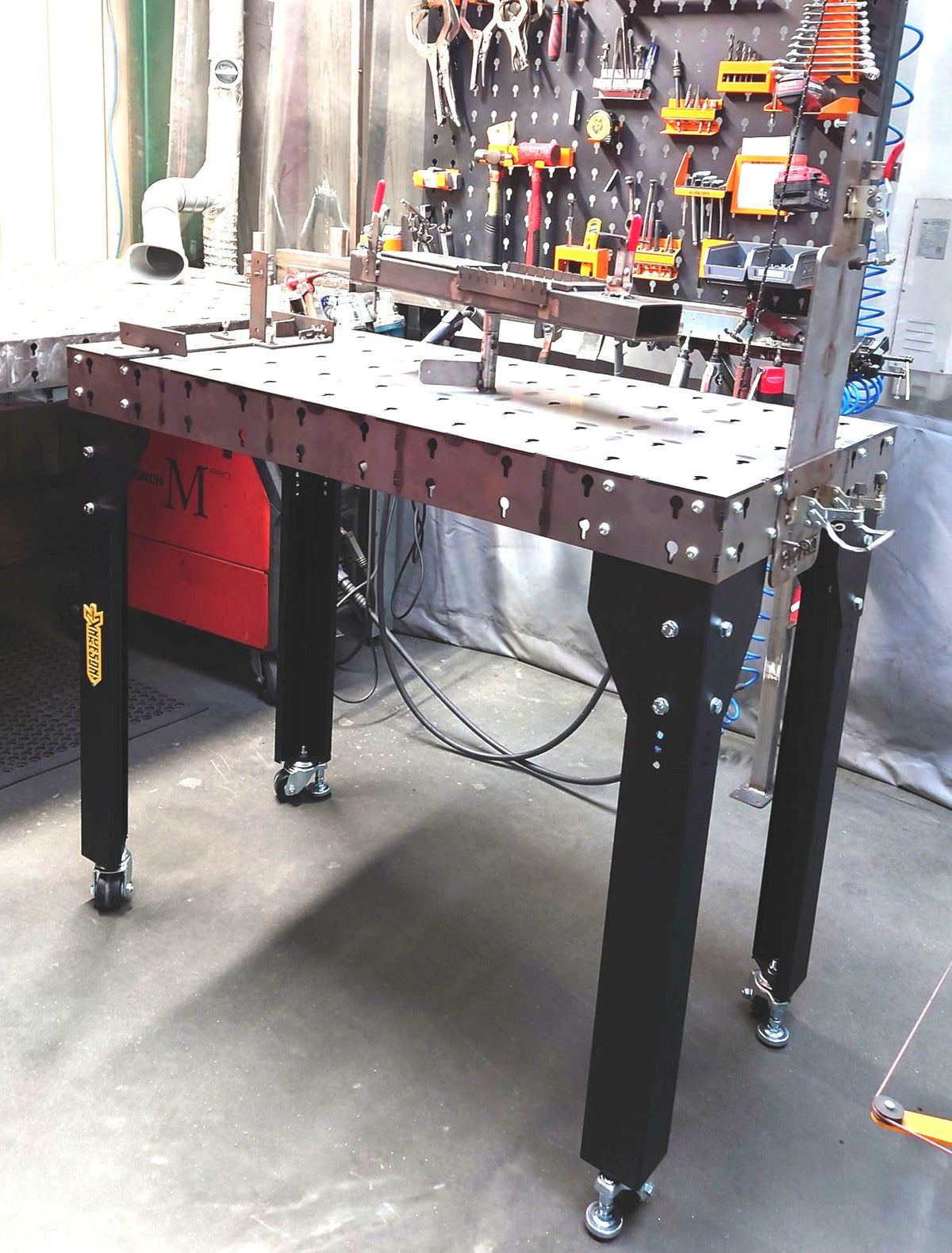 Modular Welding Table with Jigs installed on top, placed in a factory setting