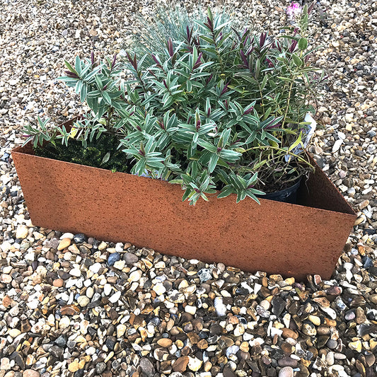 Bellamy Rustic Steel Triangle Planters on a pebble and stone floor