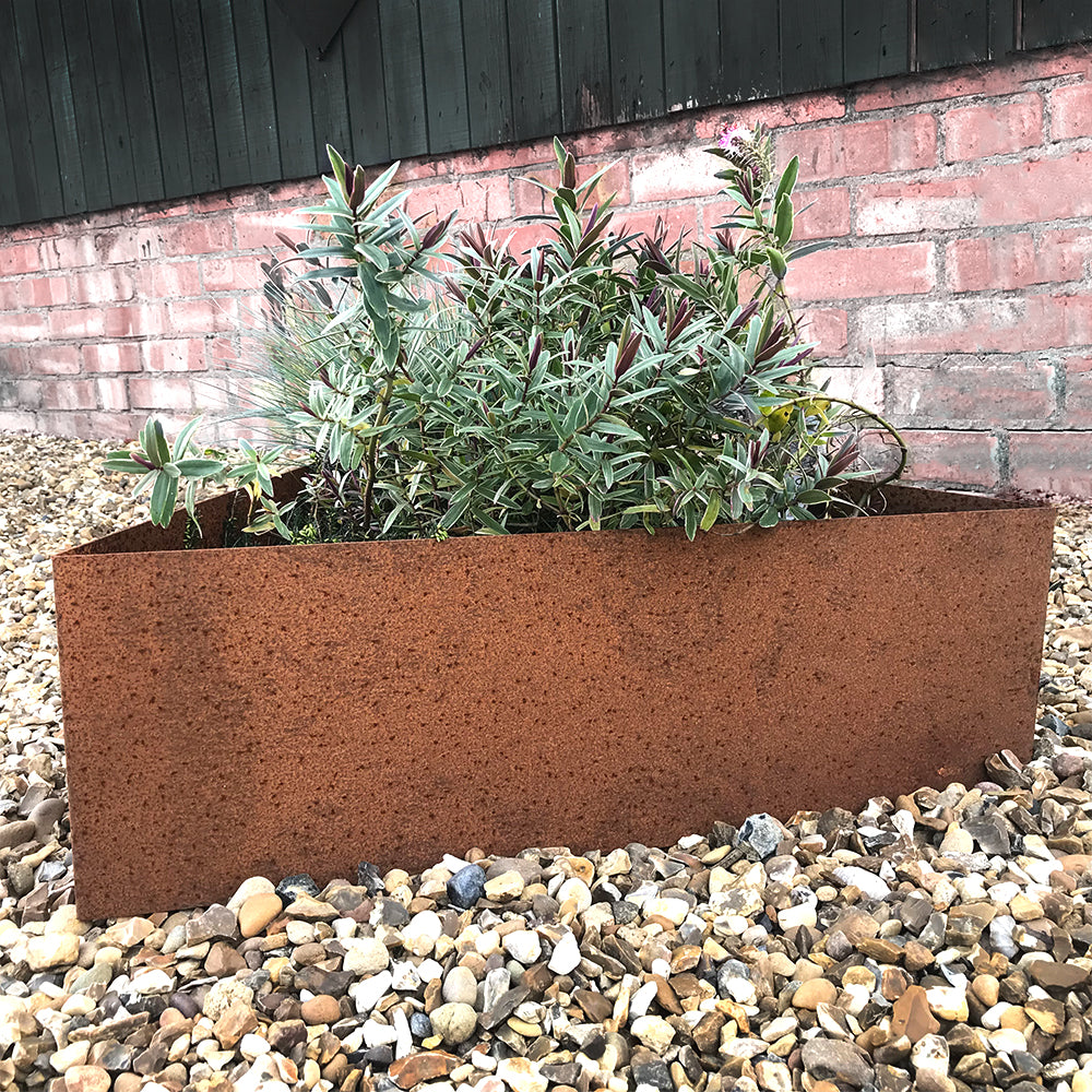 Bellamy Rustic Steel Triangle Planter placed next to a wall