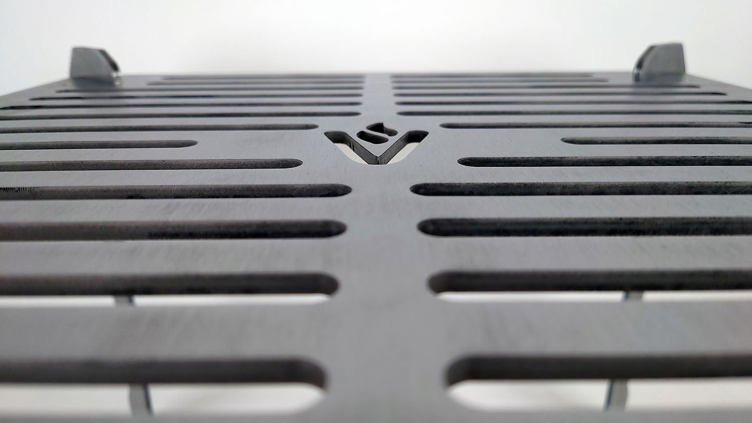 Closeup of the detailing on the cooktop showing the cutouts and the Volcann logomark