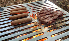 Steak being cooked, 4 sausages also on the grill