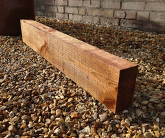 Brown-Treated Dark Brown LightGauge Sleeper positioned on some stones outside