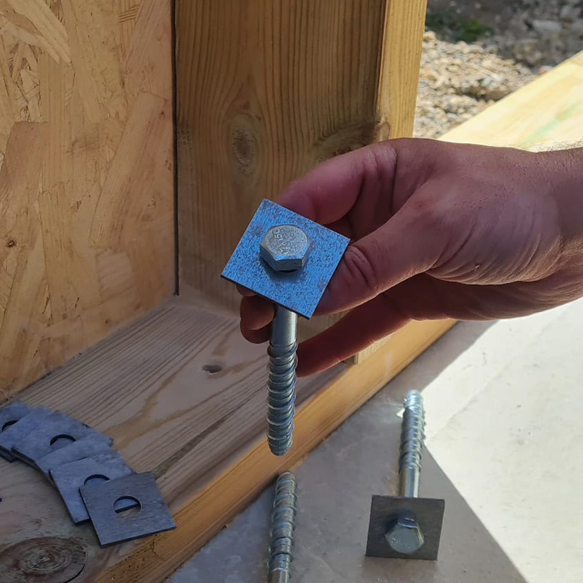 Man Holding Square Washer with a Bolt doing carpentry work