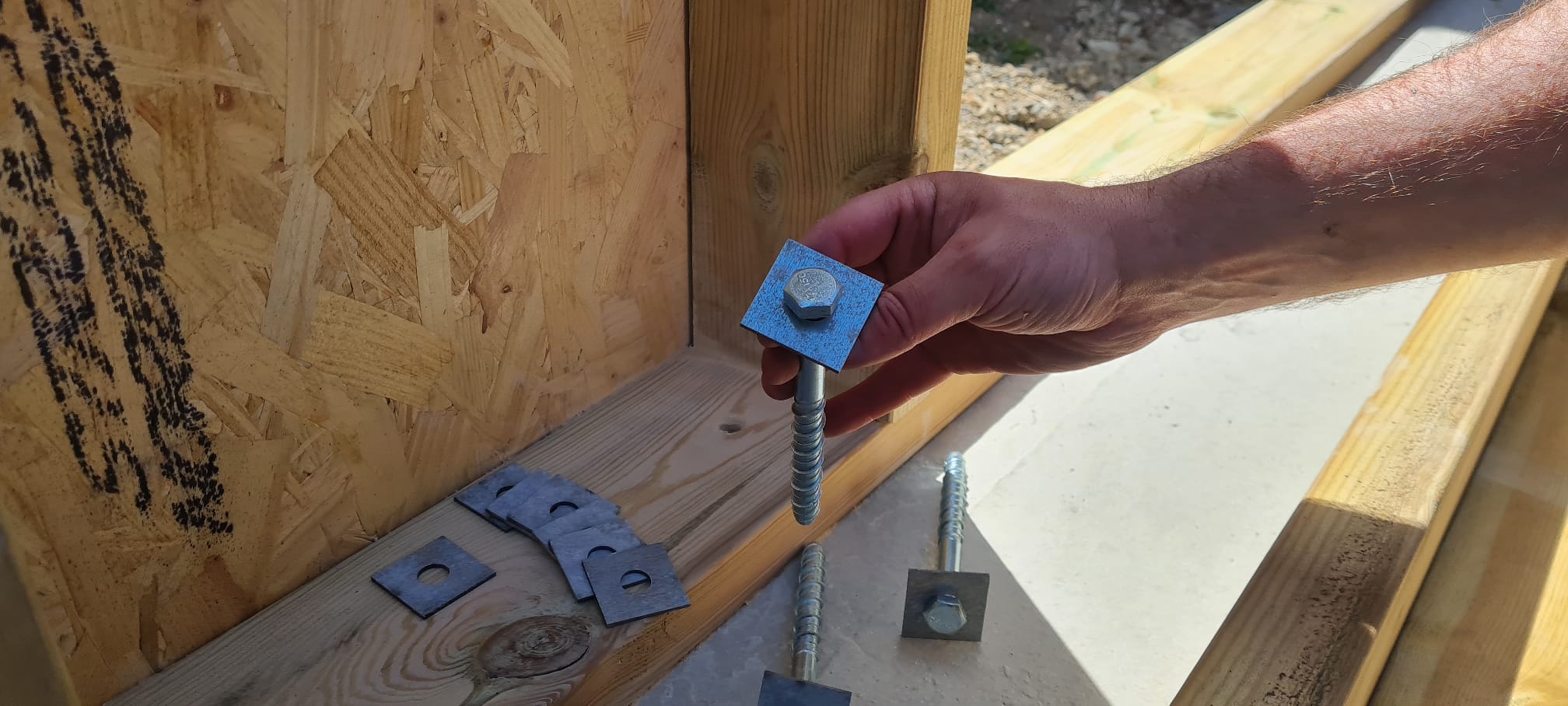 Man Holding Square Washer and Bolt