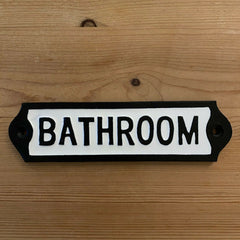 Closeup view of cast iron Bathroom sign